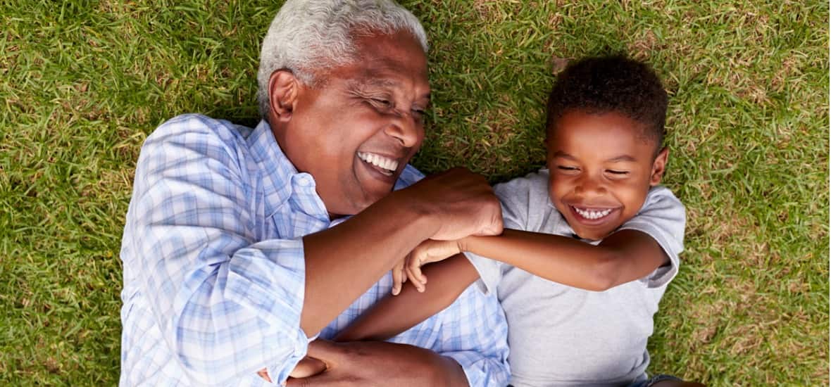 Grandfather and grandson playing on grass